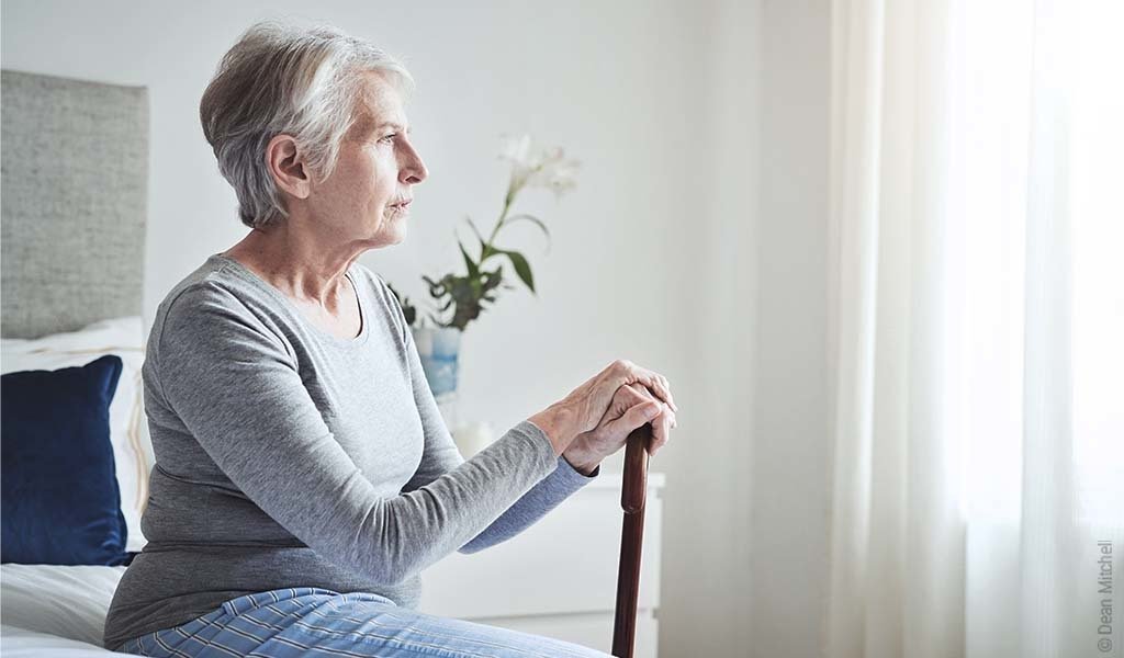 Une femme âgée regarde par la fenêtre