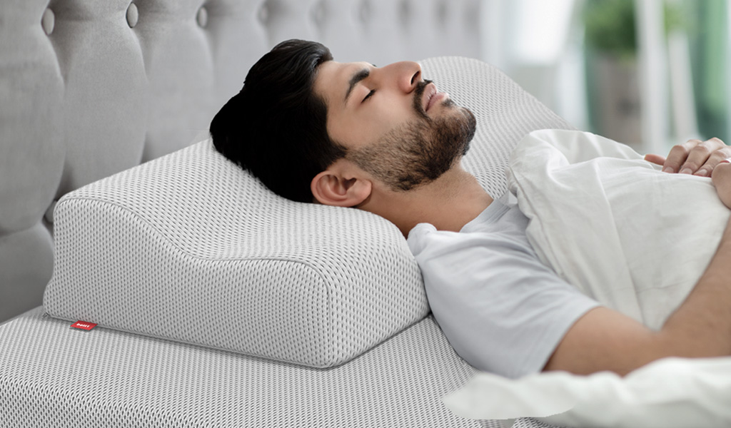 photo : un homme qui dort, la tête posée sur un oreiller ergonomique Bodyguard