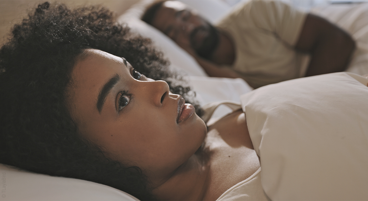 Une femme est allongée les yeux ouverts