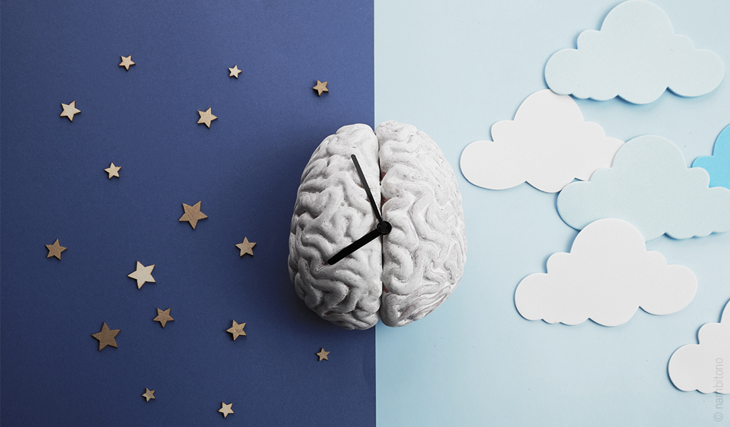 Image d'un cerveau avec des aiguilles. Sur un fond bleu marine et étoilé à gauche et bleu ciel avec des nuages à droite.