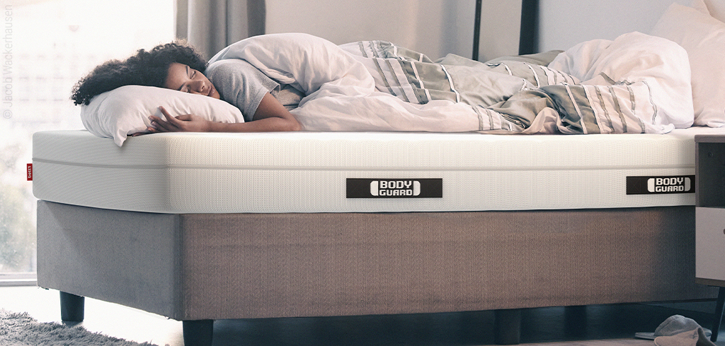 Une femme dort sur un matelas BODYGUARD
